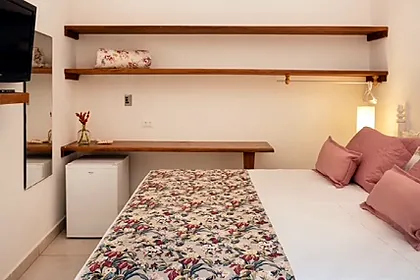 Bancada de madeira, TV smart, frigobar e ventilador de teto no quarto Clássico
