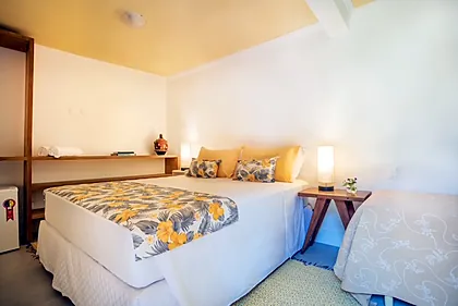 Quarto Duplo Amplo em tom amarelo, com as duas camas e janela para o jardim