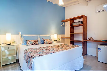 Quarto Superior com Varanda, com parede azul, cama de casal e estante de madeira